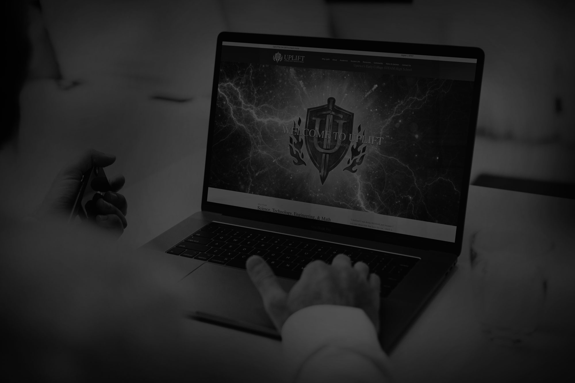 black and white image of person using laptop